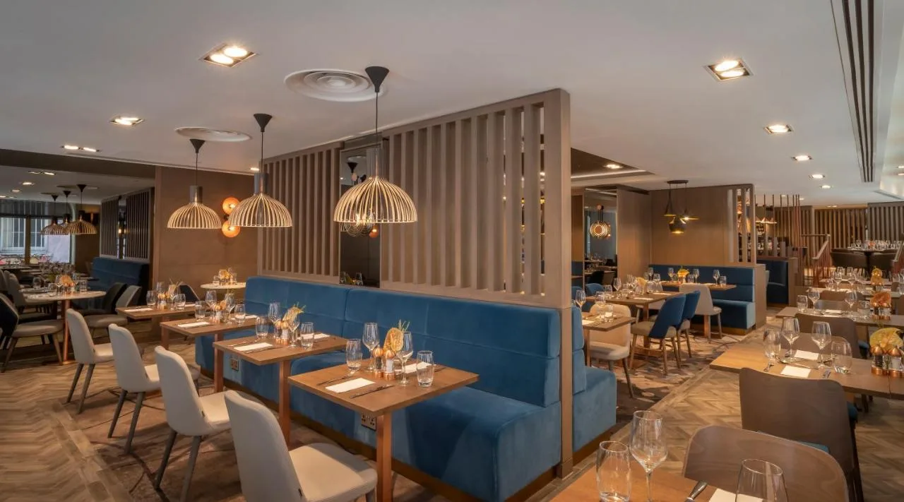 a restaurant with many tables and chairs and lights at Clayton Hotel Bristol City in Bristol